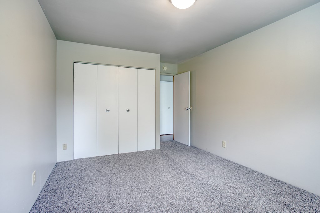 A room with a carpeted floor and a white ceiling with a light fixture.