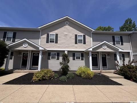 A house with a grey siding and white trim.
