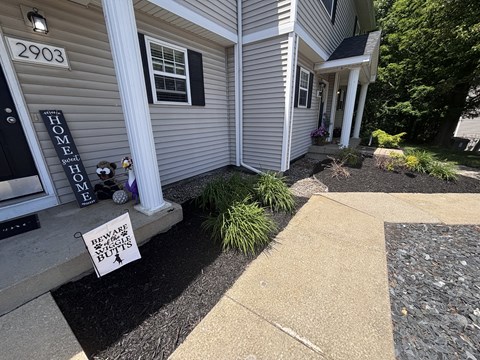 A sign on the front porch of a house warns to beware of the dog.