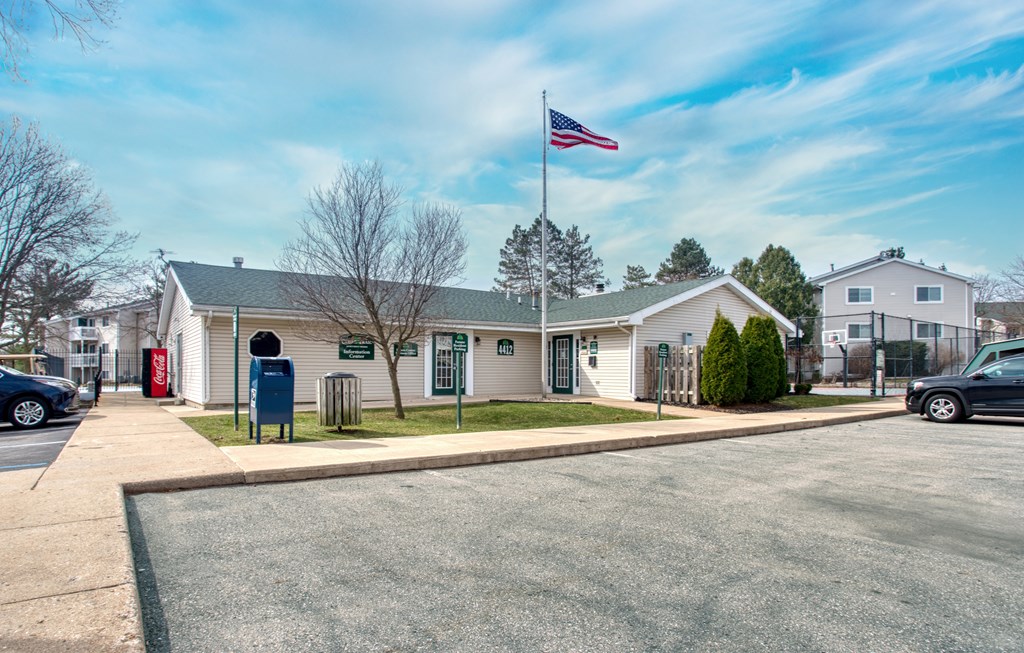 A building with a flag on top and a mailbox in front.