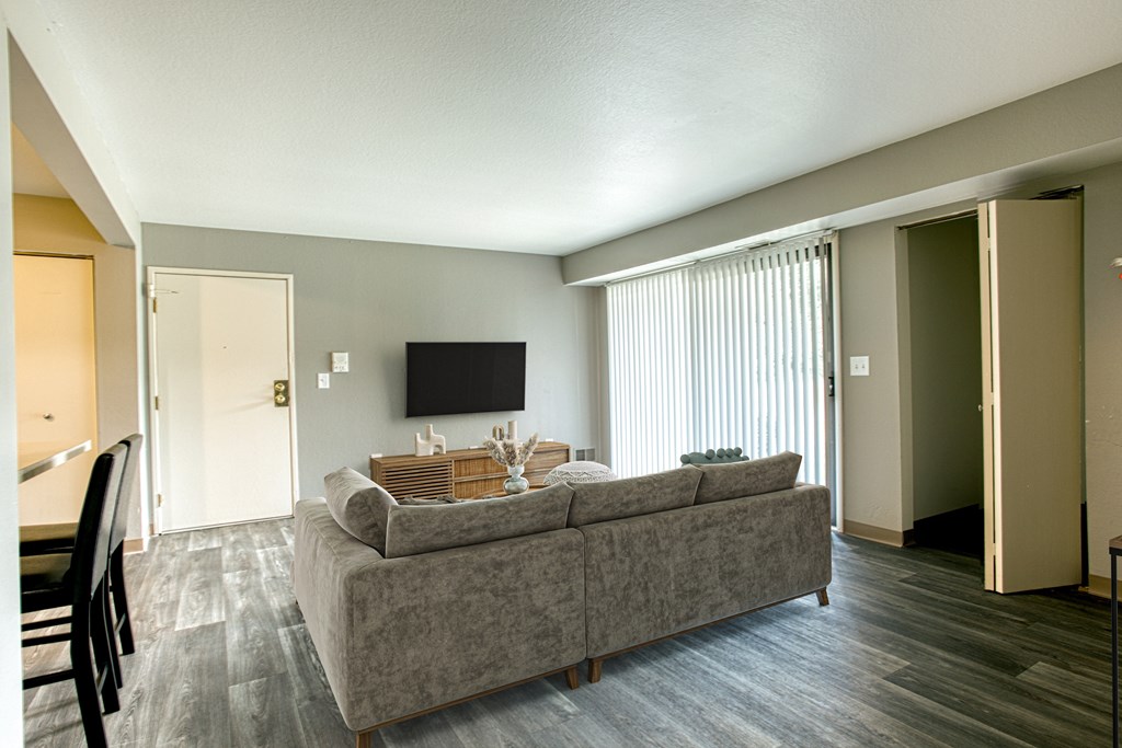 A grey couch with a wooden table in front of it.