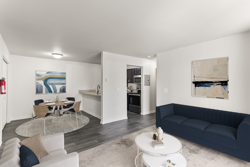 A living room with a white couch and a glass table.