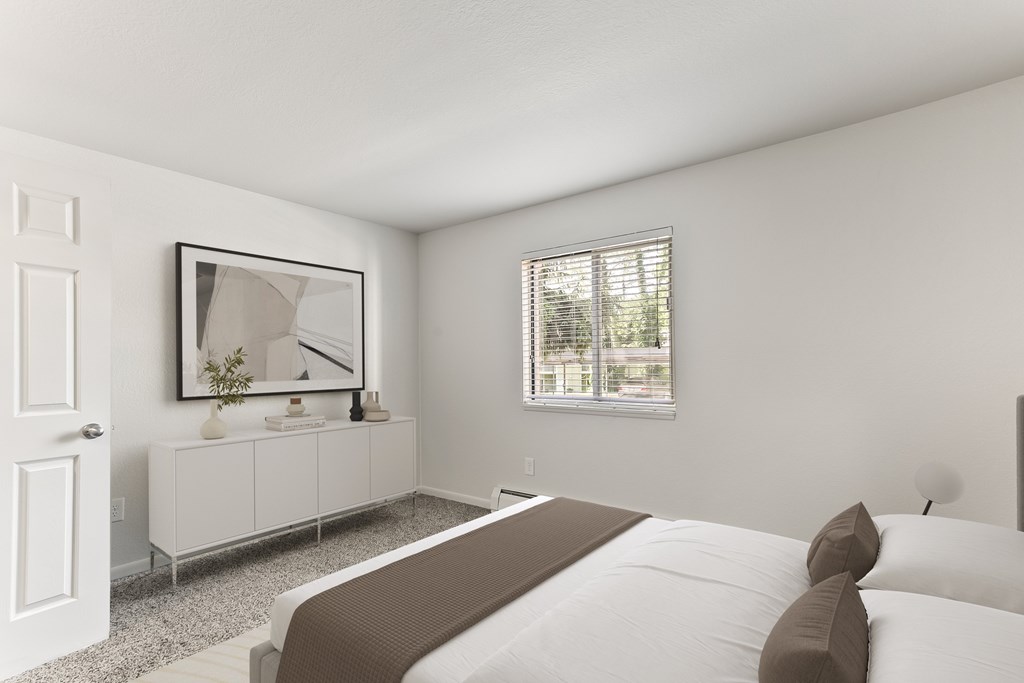 A bedroom with a large bed and a white cabinet with a mirror above it.