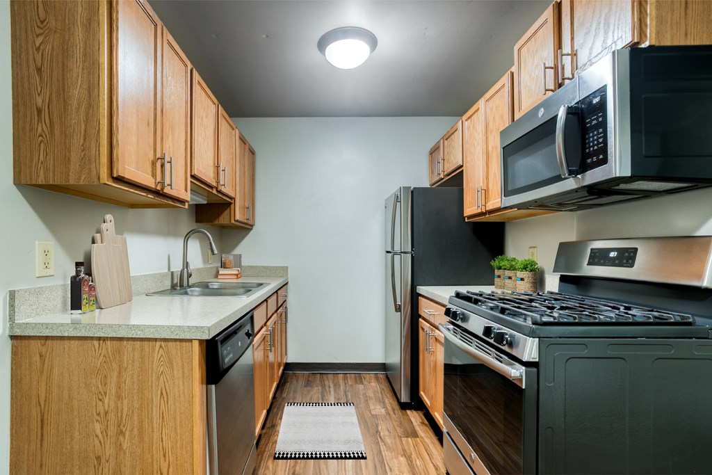 An oak style kitchen with stainless steel appliance upgrade.