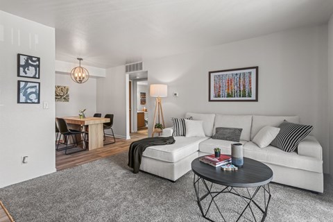 A living room with a white couch and a coffee table.