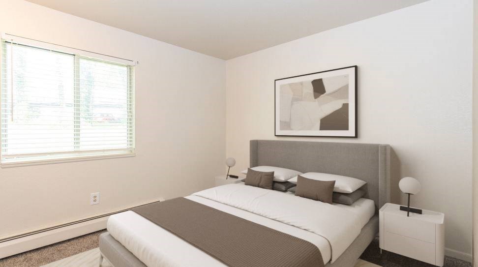 A bedroom with a large bed and a picture on the wall.