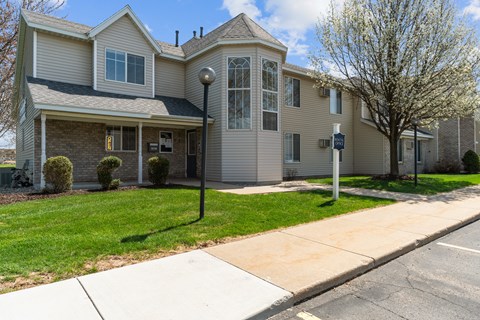 A two-story house with a garage on the first floor and a balcony on the second.
