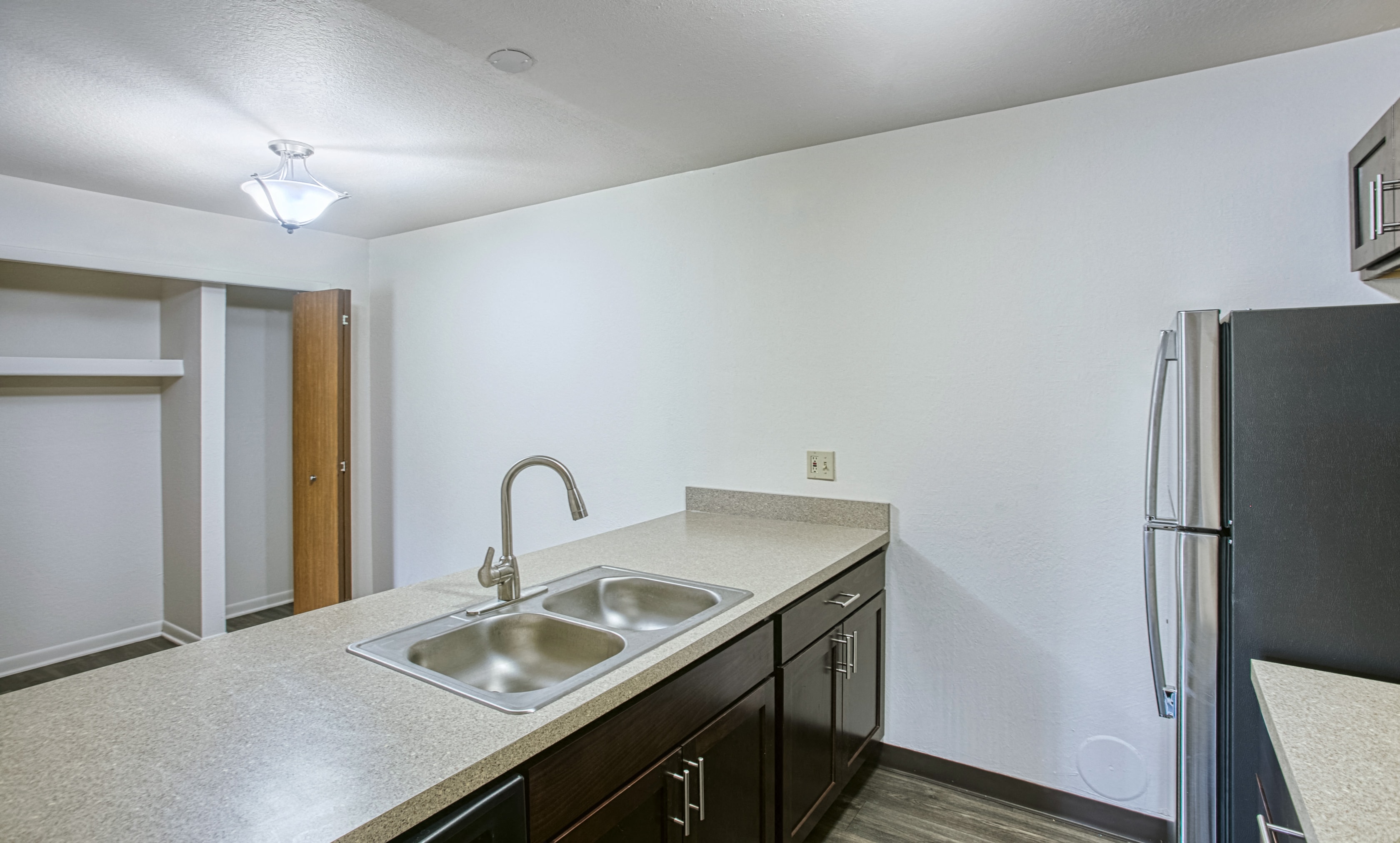 A kitchen with a sink and a refrigerator.