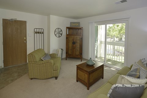 A living room with a green couch and a wooden cabinet.