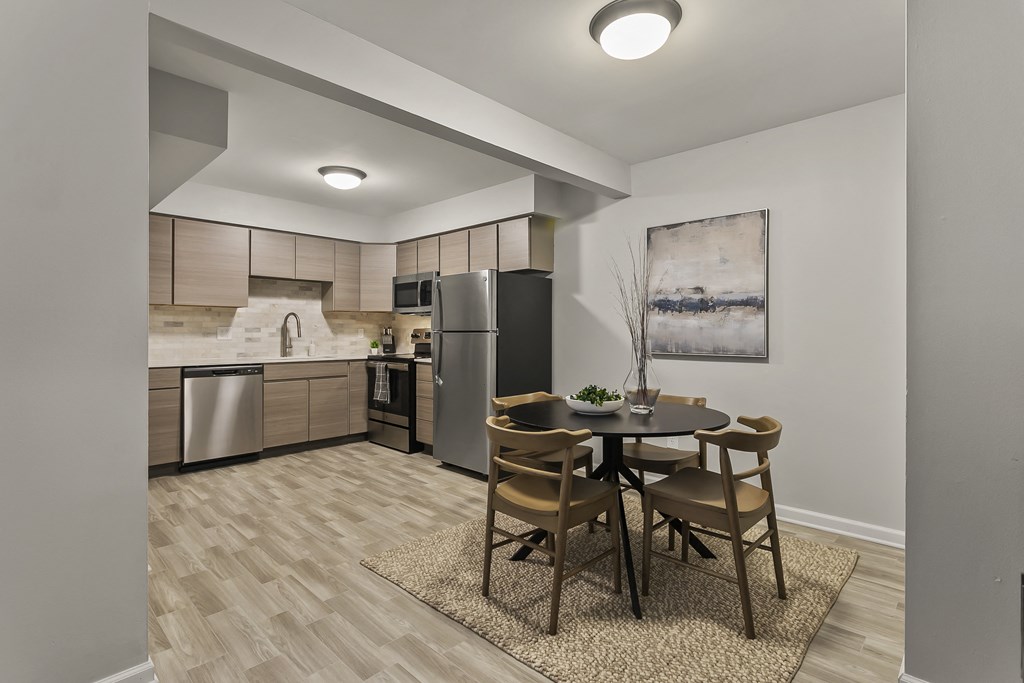 a kitchen and dining area with stainless steel appliances and a table and chairs