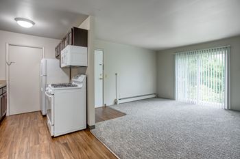 A white fridge and freezer in a room with a carpet.