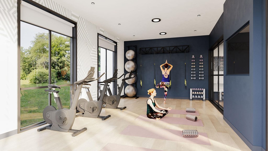 a gym with exercise equipment and a woman sitting on a yoga mat