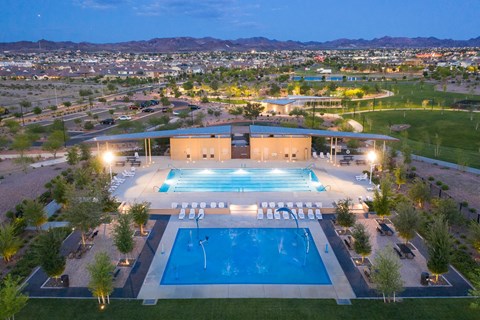 an aerial view of the pool at night with the city in the background