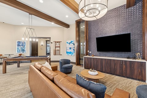 A modern living room with a pool table and a television.