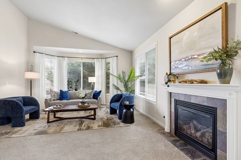 A living room with a fireplace and a painting on the wall.