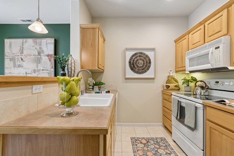 A kitchen with wooden cabinets and a white oven.