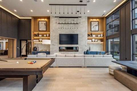 A modern living room with a pool table and a fireplace.