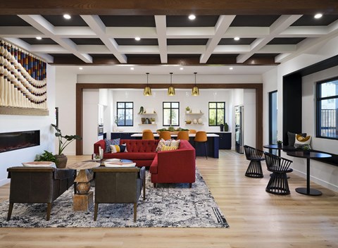 A living room with a red couch and a fireplace.