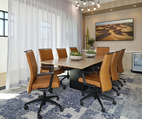 A conference room with a large table surrounded by chairs.