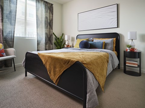 A bedroom with a large bed and a yellow blanket.