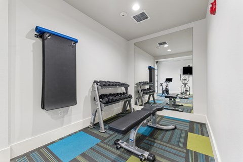 A gym room with a row of exercise equipment.