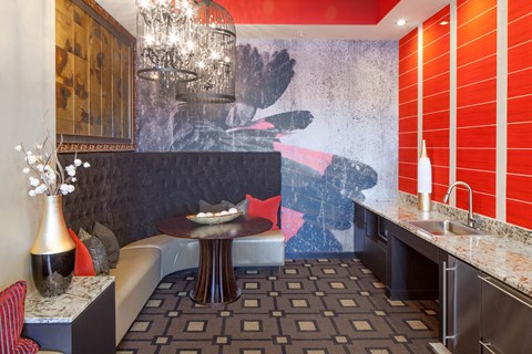 a kitchen with a table and a couch in front of a wall with a painting