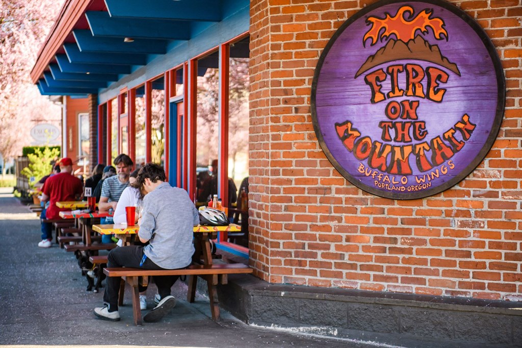people sitting at tables outside a fire on the mountain restaurant