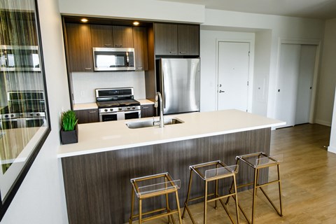 a kitchen with a counter and three bar stools