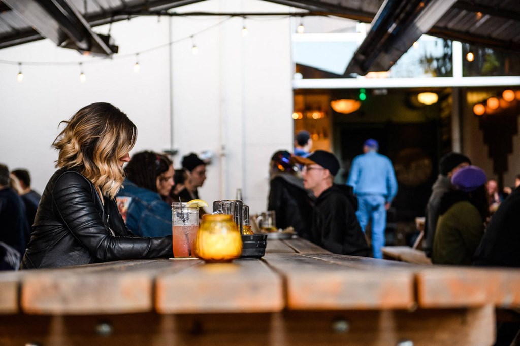 a woman sitting at a table in a bar with a drink