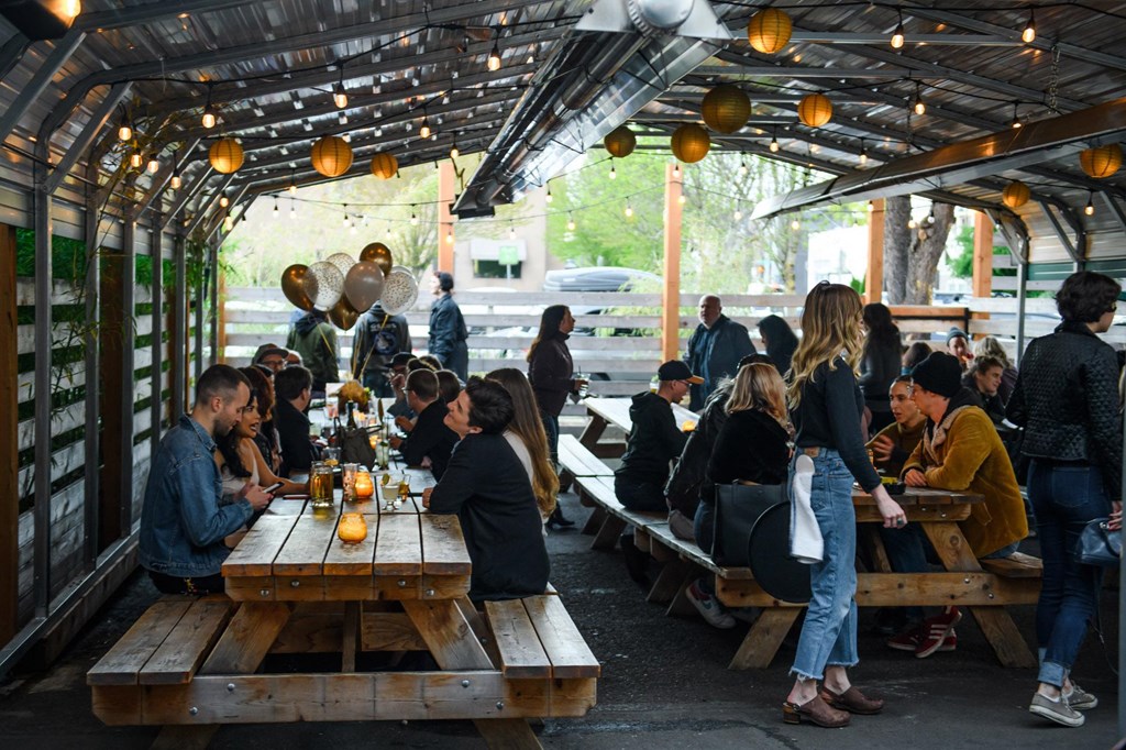 a group of people sitting at tables in a beer tent