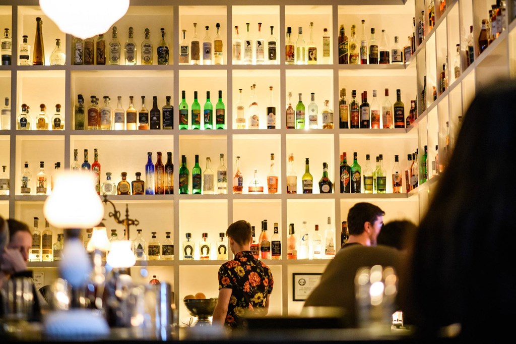 the back wall of a bar filled with bottles of alcohol