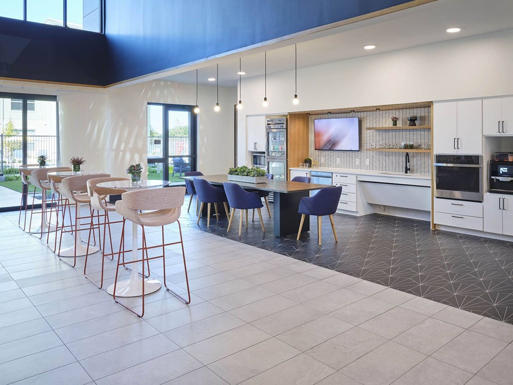 a kitchen with a bar and chairs and a table