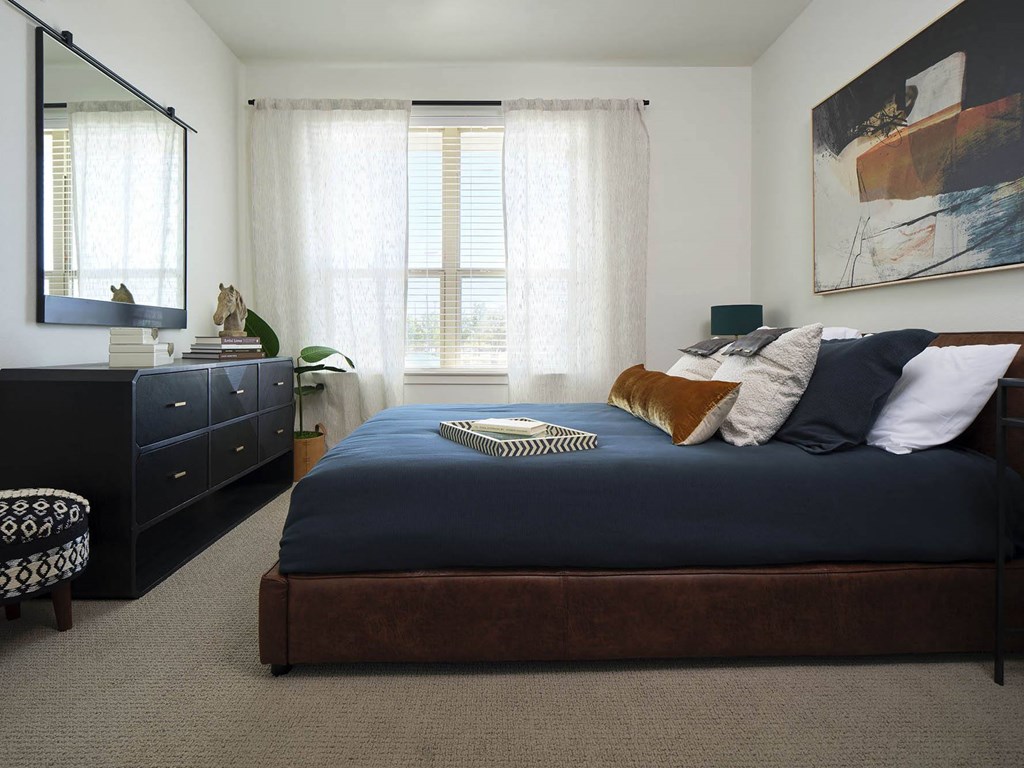 a bedroom with a large bed and a dresser