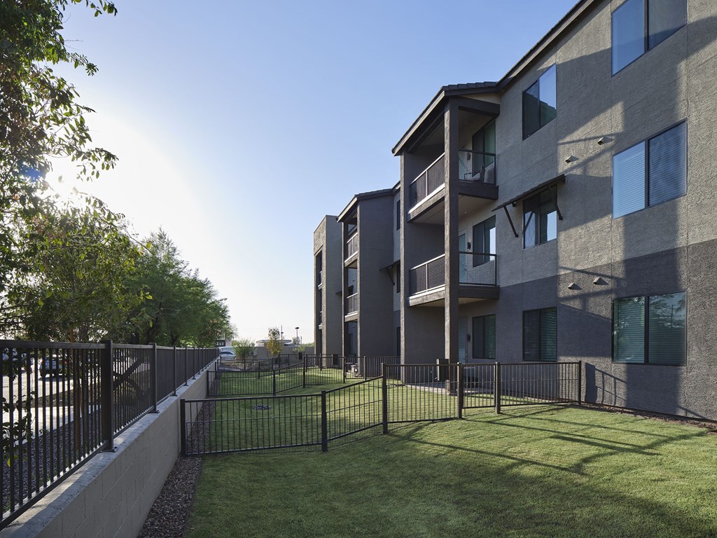 an apartment building with a yard and a fence
