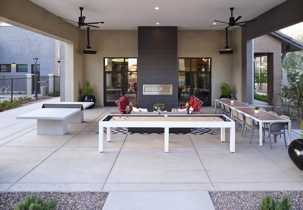 an outdoor patio with tables and chairs and a fireplace