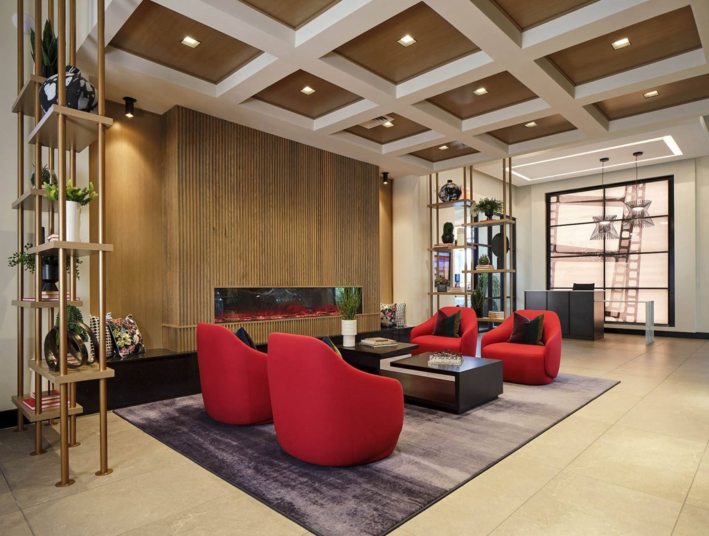 a living room with red chairs and a fireplace