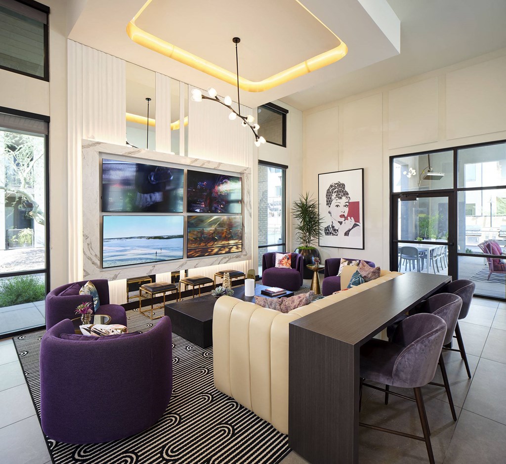 a living room with purple chairs and a table