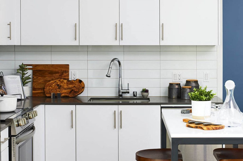 a white kitchen with white cabinets and a sink
