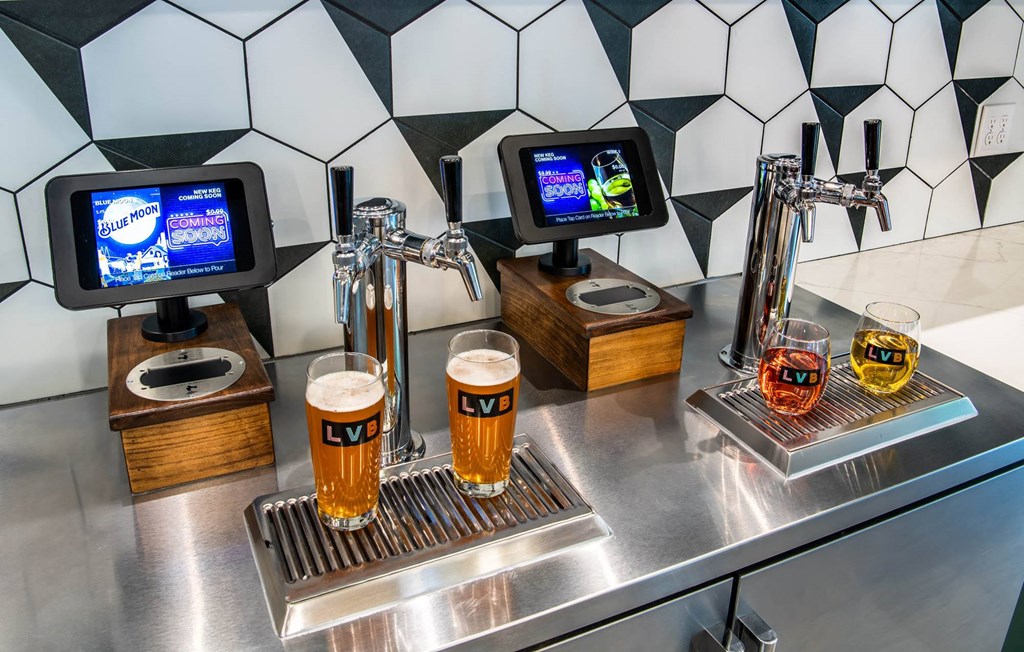 a bar with glasses of beer on a stainless steel counter