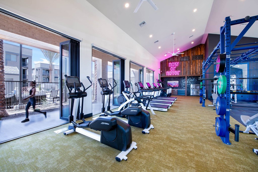 a gym with cardio equipment and windows at aria resort and spa