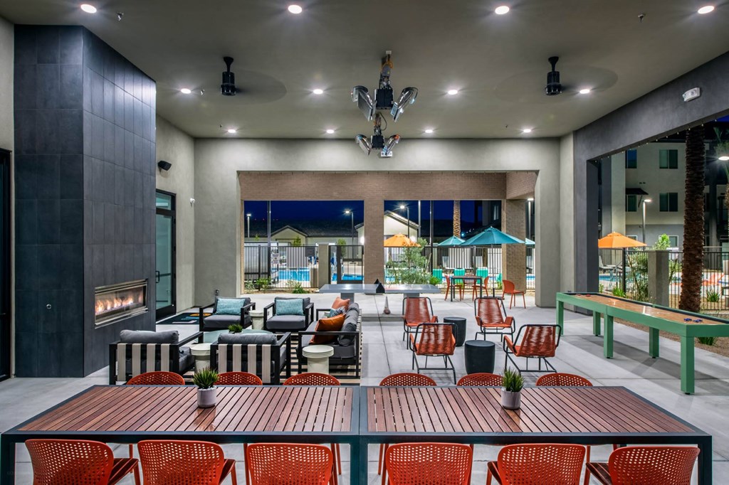 a lounge area with tables and chairs and a fireplace