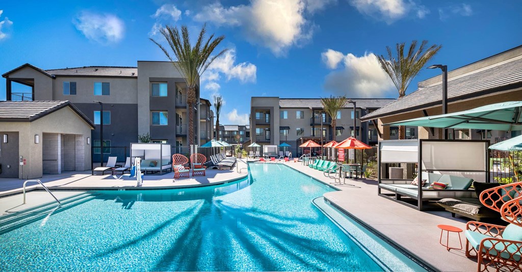 a swimming pool with lounge chairs and umbrellas