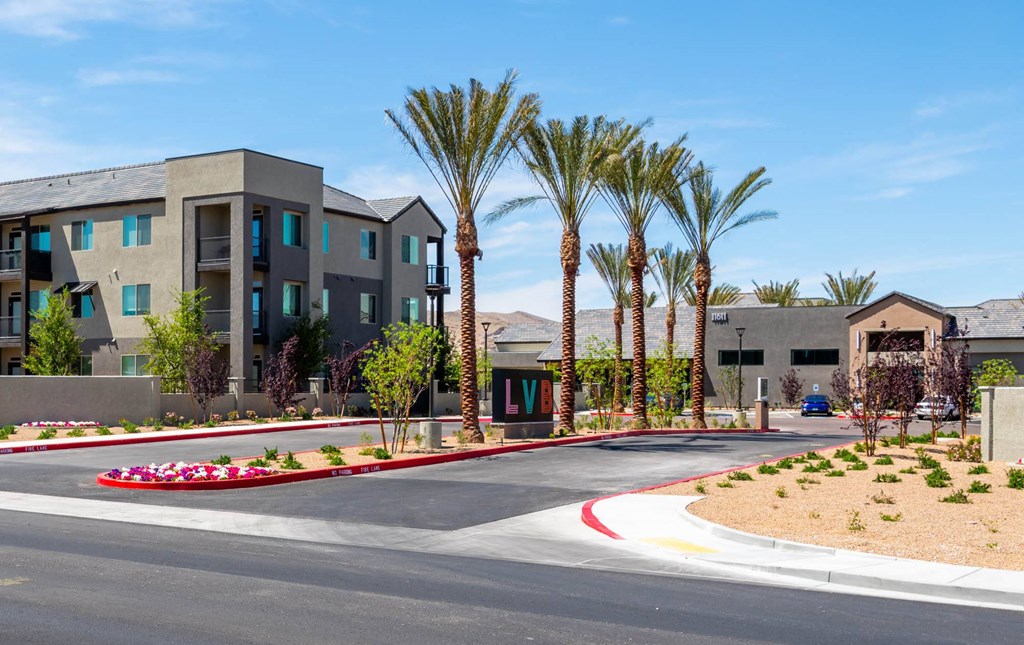 a street view of an apartment building with palm trees