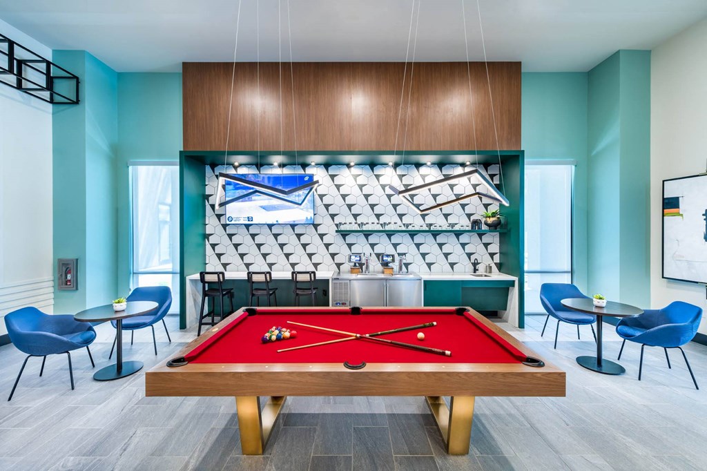 a red pool table in a room with a bar and a scoreboard
