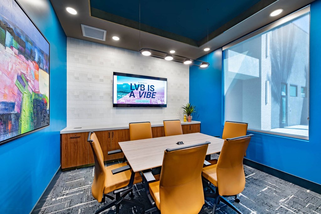 a conference room with a table and chairs and a tv