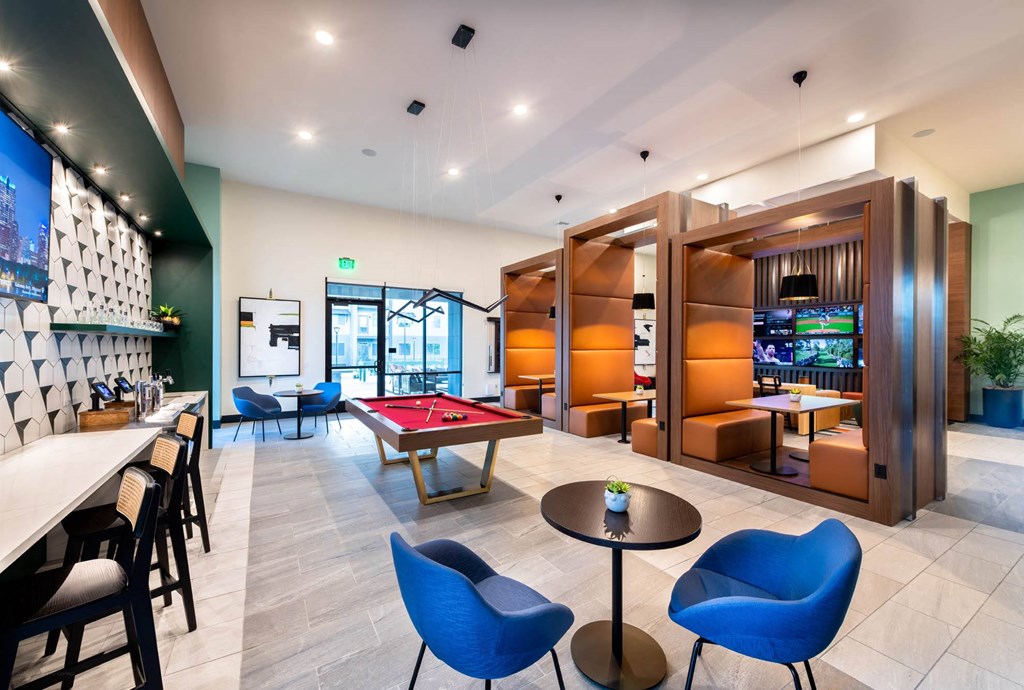 a game room with a pool table and a bar