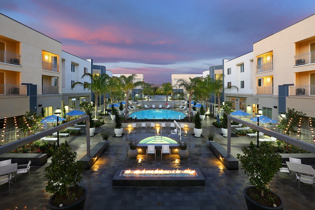 a view of a resort with a swimming pool at night