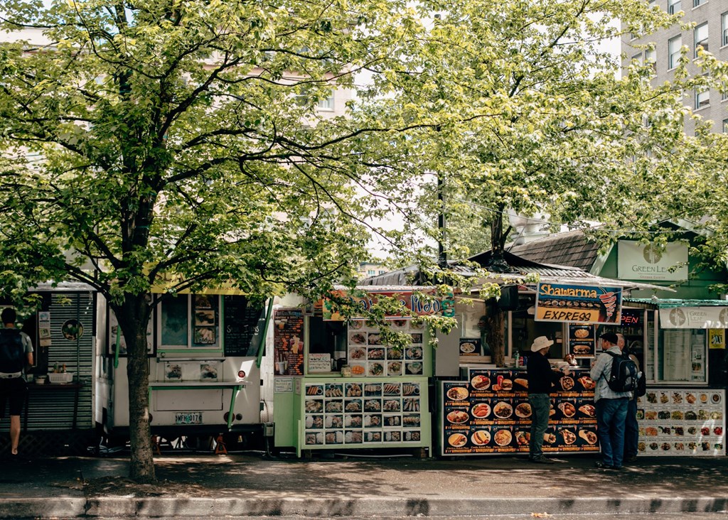 a row of food trucks on the side of a street