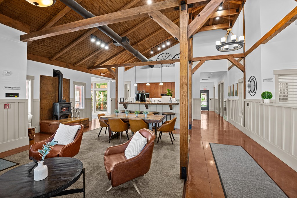 a living room with chairs and a table and a kitchen
