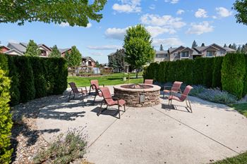 an outdoor patio with a fire pit and chairs